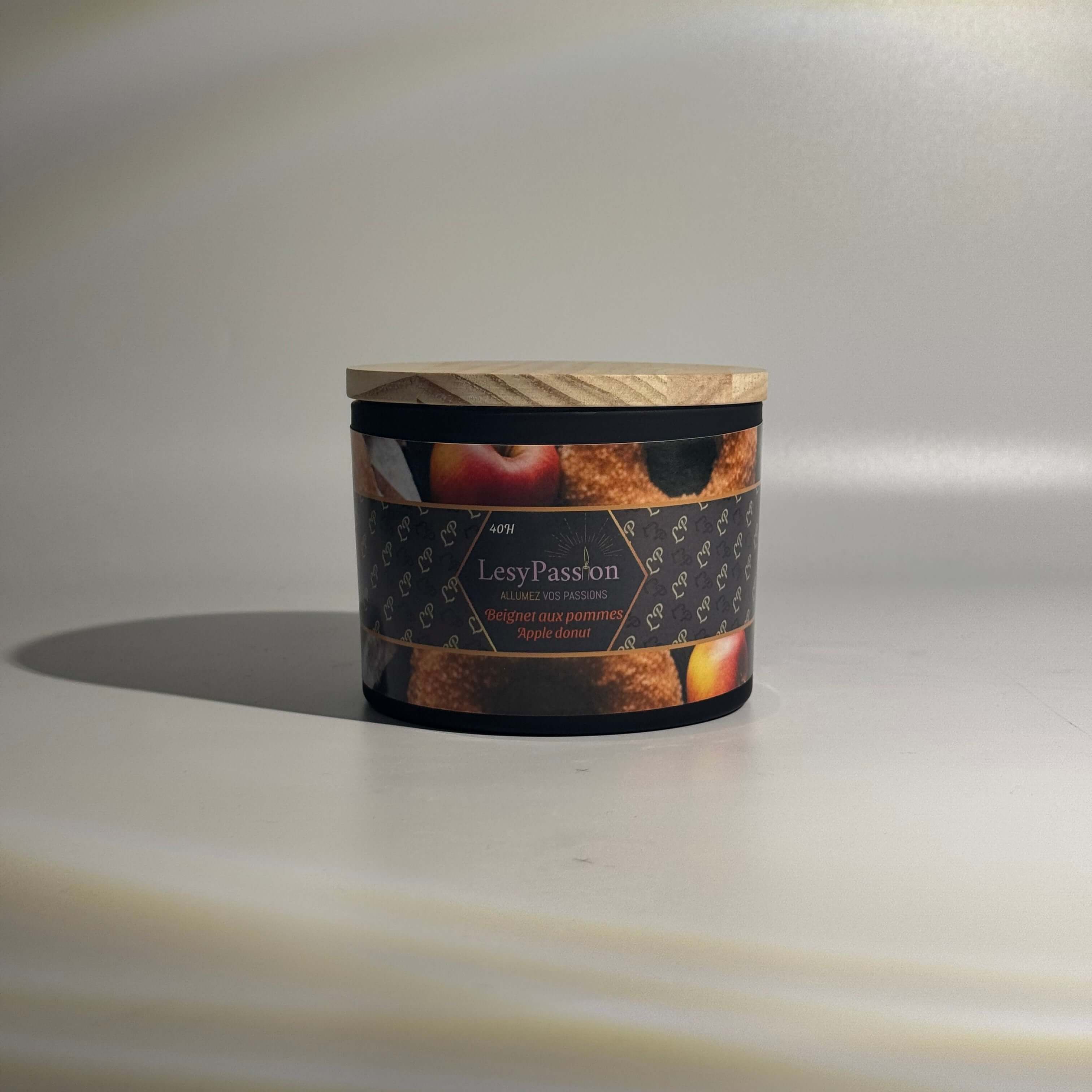 Bougie LesyPassion 15oz au « Beignet aux pommes » avec couvercle en bois et étiquettes illustratives.