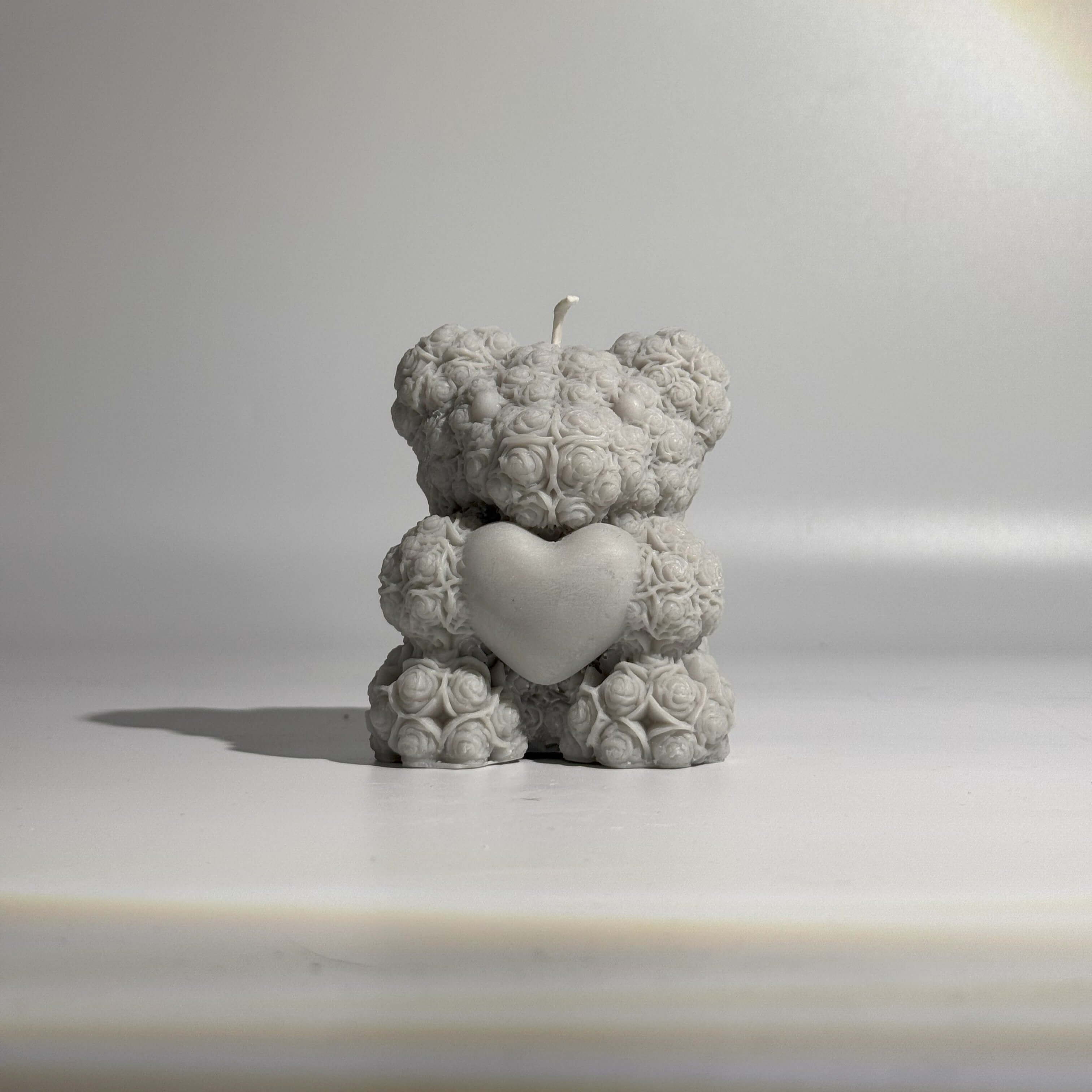 Ourson en rose en cire, représentation d'un ours décoré de fleurs, ajoutant une touche d'amour et de chaleur.