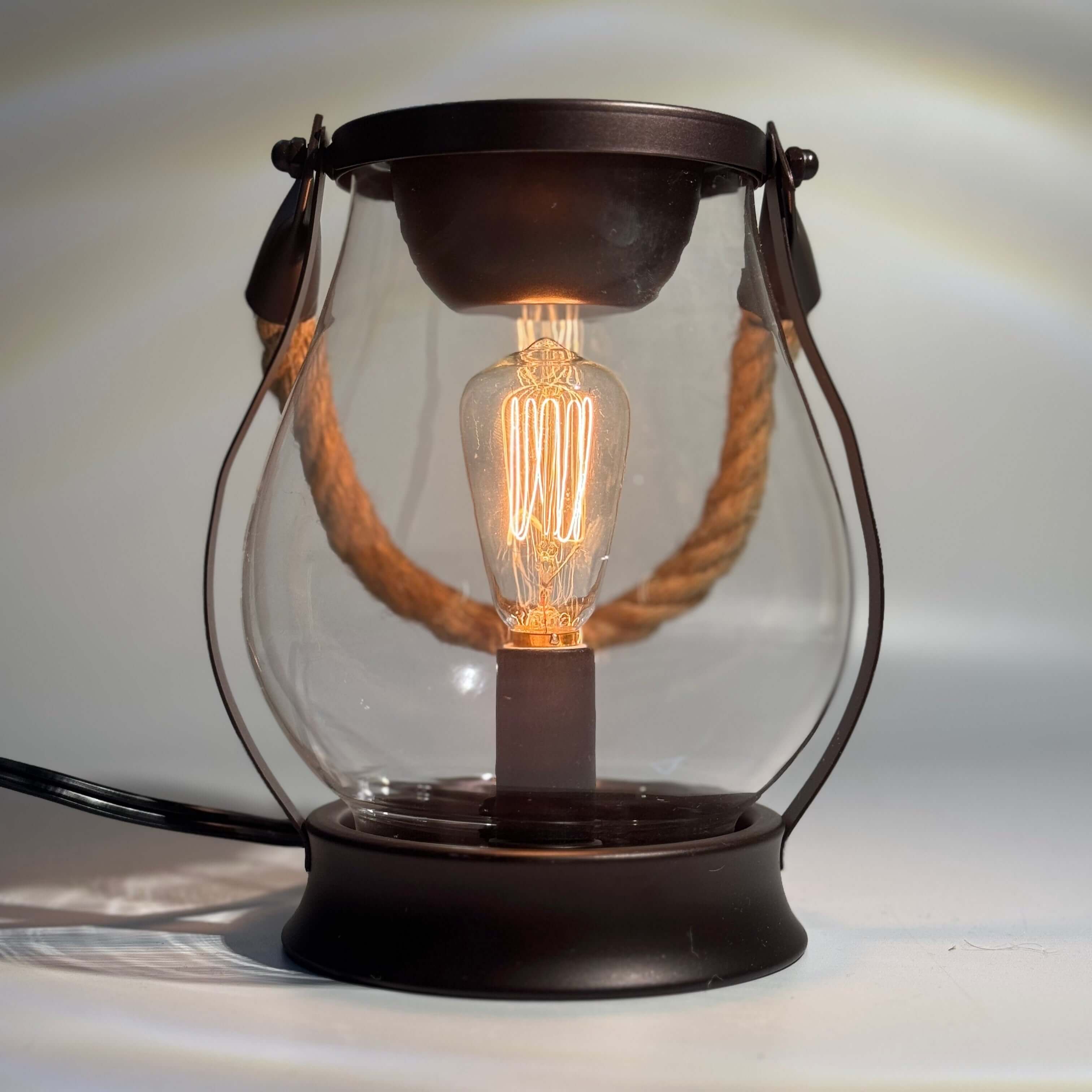 La lampe à l’huile avec ampoule Edison et poignée en corde, ajoutant une touche vintage à votre décor.